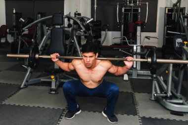 Asyalı kaslı adamlar spor salonunda ağırlık kaldırıyor..