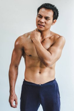 Beyaz sırt egzersizi yüzünden boynunda kas hasarı olan Asyalı bir adam.