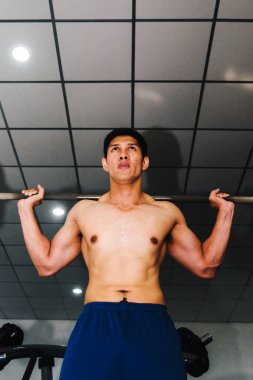 Asyalı kaslı adamlar spor salonunda ağırlık kaldırıyor..