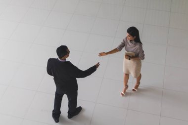 Patron ve sekreter selamlaşmak için el sıkışıyorlar. 