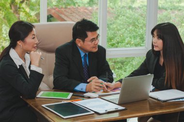 Yöneticiler ve çalışanlar iş yerinde iş konuşuyorlar.