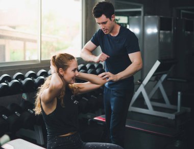 Güzel bir kadın egzersiz ve spor yapıyor. Antrenör veriyor.