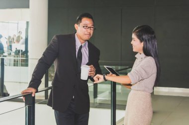 Yöneticiler ve sekreterler kapalı koridorlarda yürüyorlar.