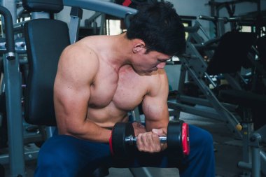 Asyalı kaslı adamlar spor salonunda ağırlık kaldırıyor..