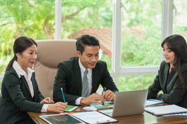 Yöneticiler ve çalışanlar iş yerinde iş konuşuyorlar.