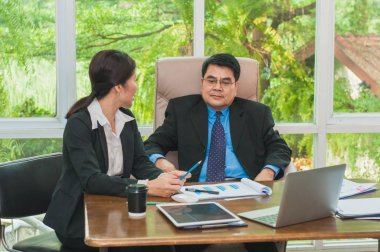 Yöneticiler ve sekreterler ofiste iş konuşuyorlar..