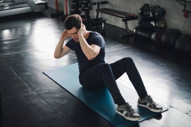 Young man caucasian Being exercised by a sit-up on yoga mat. He 