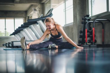 Güzel bir sporcu bir takım elbise giydi. Bir kas üzerinde gerinme