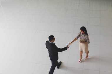 Patron ve sekreter selamlaşmak için el sıkışıyorlar. 