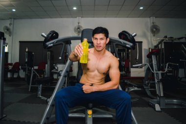 Asyalı adamın spor salonunda kas egzersizi var ve çok yorgun.