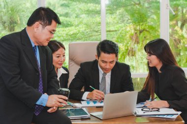 Yöneticiler ve çalışanlar iş yerinde iş konuşuyorlar.