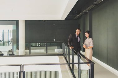 Yöneticiler ve sekreterler kapalı koridorlarda yürüyorlar.