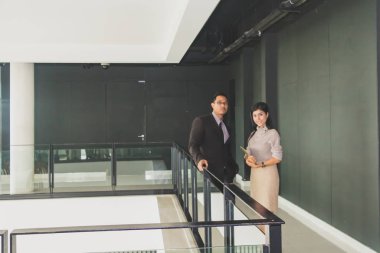 Yöneticiler ve sekreterler kapalı koridorlarda yürüyorlar.