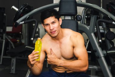 Asyalı adamın spor salonunda kas egzersizi var ve çok yorgun.