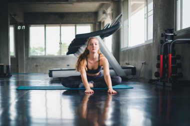 Güzel bir sporcu bir takım elbise giydi. Bir kas üzerinde gerinme