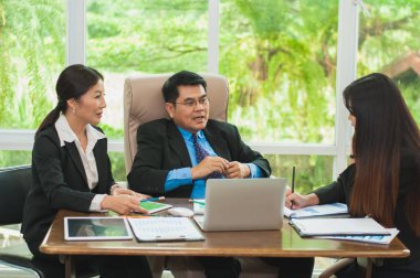 Yöneticiler ve çalışanlar iş yerinde iş konuşuyorlar.