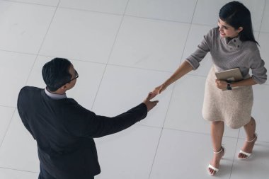 Patron ve sekreter selamlaşmak için el sıkışıyorlar. 