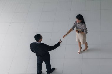 Patron ve sekreter selamlaşmak için el sıkışıyorlar. 