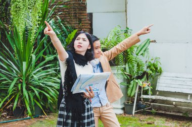 Turist haritasını izleyen Asyalı erkek ve kadınlar