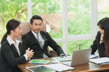 Yöneticiler ve çalışanlar iş yerinde iş konuşuyorlar.