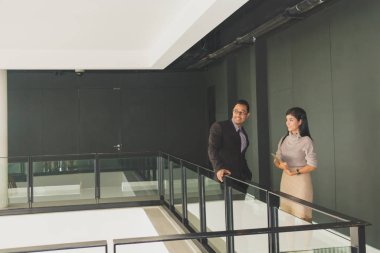 Yöneticiler ve sekreterler kapalı koridorlarda yürüyorlar.