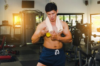 Asyalı adam spor salonunda kas egzersizi yapıyor. Ve Asyalı yakışıklı bir müzisyen.