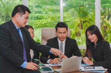 Yöneticiler ve çalışanlar iş yerinde iş konuşuyorlar.