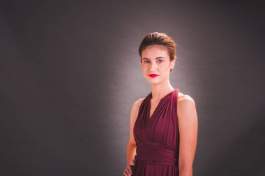 Kırmızı elbiseli güzel bir Asyalı kız GR 'ın önünde duruyor.