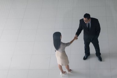 Patron ve sekreter selamlaşmak için el sıkışıyorlar. 