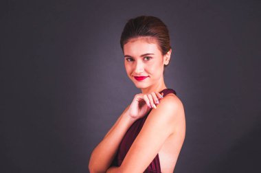 Kırmızı elbiseli güzel bir Asyalı kız GR 'ın önünde duruyor.