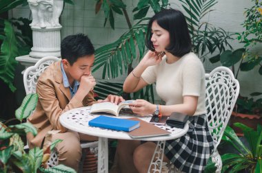 Kız kardeşi evin bahçesinde erkek kardeşine öğretiyor.