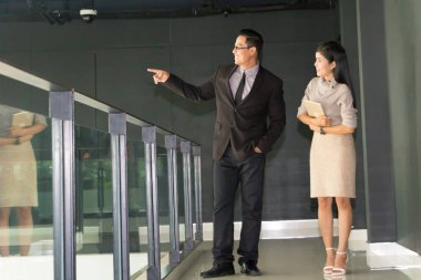 Yöneticiler ve sekreterler kapalı koridorlarda yürüyorlar.