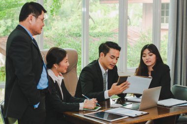 Yöneticiler ve çalışanlar iş yerinde iş konuşuyorlar.