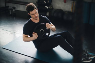 Young man caucasian was exercising by the use weight plate on yo
