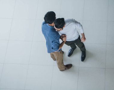 Asyalı ofis çalışanları ofis lobisinde durup konuşuyorlar..