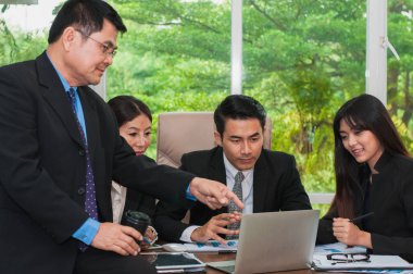 Yöneticiler ve çalışanlar iş yerinde iş konuşuyorlar.