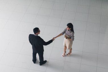 Patron ve sekreter selamlaşmak için el sıkışıyorlar. 
