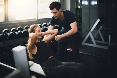 Güzel bir kadın egzersiz ve spor yapıyor. Antrenör veriyor.