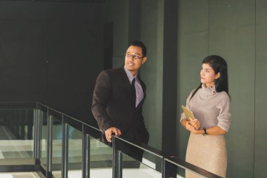 Yöneticiler ve sekreterler kapalı koridorlarda yürüyorlar.