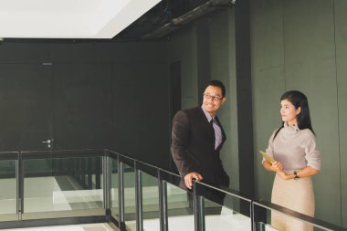 Yöneticiler ve sekreterler kapalı koridorlarda yürüyorlar.