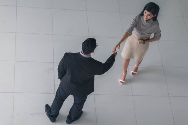 Patron ve sekreter selamlaşmak için el sıkışıyorlar. 