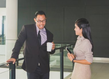 Yöneticiler ve sekreterler kapalı koridorlarda yürüyorlar.