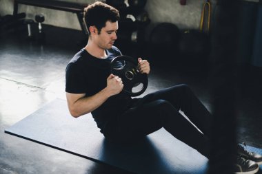 Young man caucasian was exercising by the use weight plate on yo