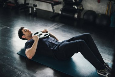 Young man caucasian was exercising by the use weight plate on yo