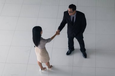 Patron ve sekreter selamlaşmak için el sıkışıyorlar. 