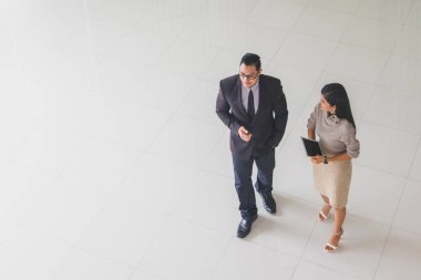 Yöneticiler ve sekreterler kapalı koridorlarda yürüyorlar.