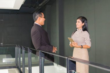 Yöneticiler ve sekreterler kapalı koridorlarda yürüyorlar.