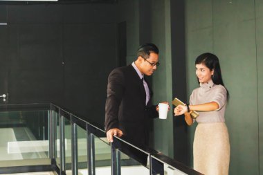 Yöneticiler ve sekreterler kapalı koridorlarda yürüyorlar.