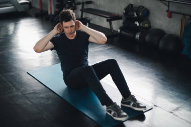 Young man caucasian Being exercised by a sit-up on yoga mat. He 