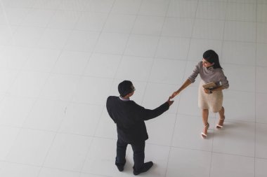 Patron ve sekreter selamlaşmak için el sıkışıyorlar. 